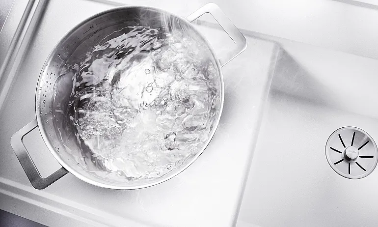Topf mit kochendem Wasser auf Küchenspüle