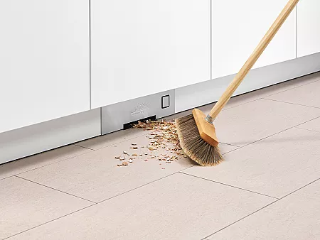 Der Einbau-Sockelsauger im Küchensockel saugt Dreck auf