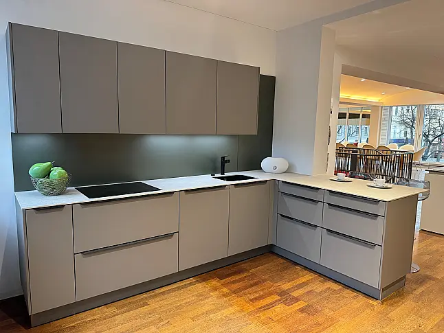 Moderne L-Küche mit innovativem Pocket-Door-System und Keramik-Arbeitsplatte