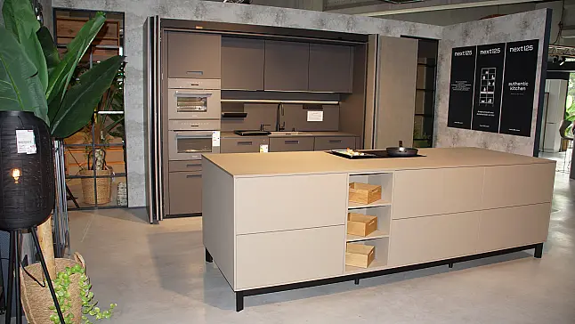 Moderne Ausstellungsküche von next125 mit Kochinsel in Saharabeige und Pocketsystem