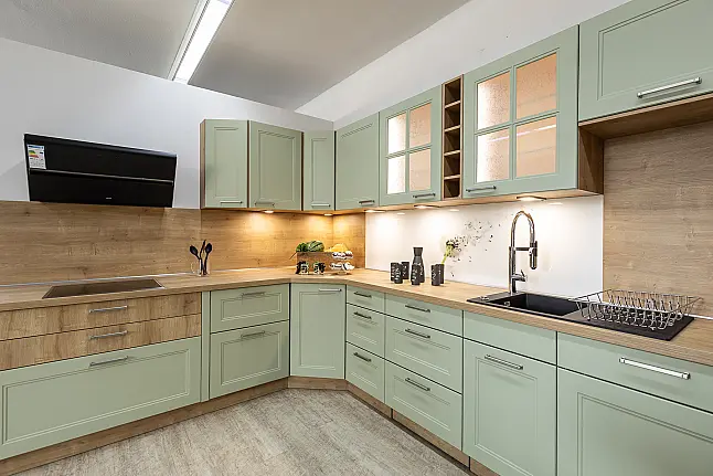 „Avocado trifft Chalet-Eiche“ – außergewöhnliche Landhausküche in L-Form mit lackierten Fronten