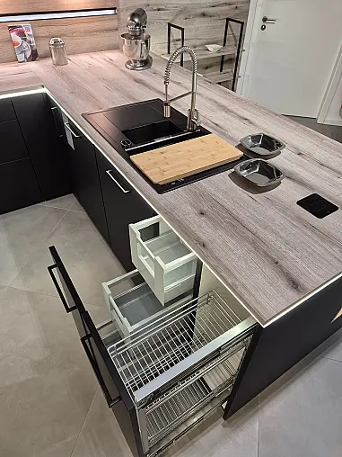 Stylische schwarze Designerküche mit holzfarbenem Arbeitsplatten- und Abdeckbodendekor