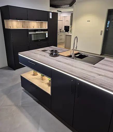 Stylische schwarze Designerküche mit holzfarbenem Arbeitsplatten- und Abdeckbodendekor