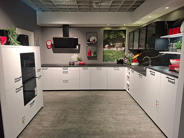 Stilvolle, moderne Ausstellungsküche mit eleganten Fronten in Kristallweiß matt und einer perfekt abgestimmten Arbeitsplatte im Dekor Marmor Vena. Die hochwertige Küche wird inklusive erstklassiger AEG-Elektrogeräte und Edelstahl-Spüle sofort abholbereit.