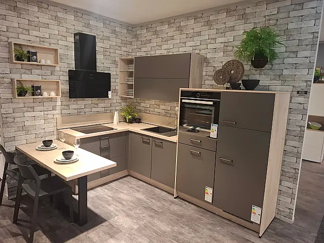 Moderne L-Ausstellungsküche in mattem Vulkangrau kombiniert mit einer warmen Arbeitsplatte in Eiche Montreal Nachbildung. Inklusive moderner Beko Elektrogeräte und Spüle, sofort verfügbar und abholbereit in der Ausstellung.