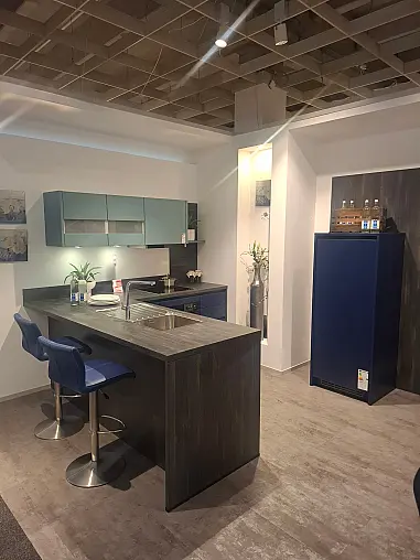 Moderne L-Küche mit freistehender Insel, Fronten in Aquablau-Satin und markanter Castelleiche-Optik