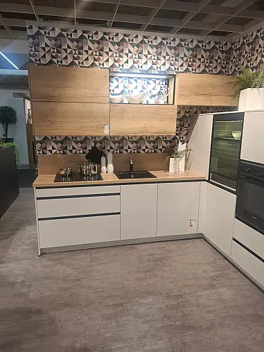 Moderne, stilvolle L-Küche in Kristallgrau mit warmen Akzenten in Alteiche provence und eleganter Onyxschwarzer Griffleiste