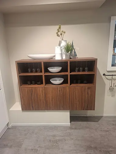 Moderne, elegante L-Küche in mattem Kristallweiß mit hochwertiger Geräteaustattung und Nischenverkleidung in Nussbaum