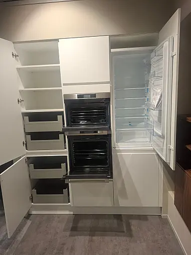 Moderne, elegante L-Küche in mattem Kristallweiß mit hochwertiger Geräteaustattung und Nischenverkleidung in Nussbaum
