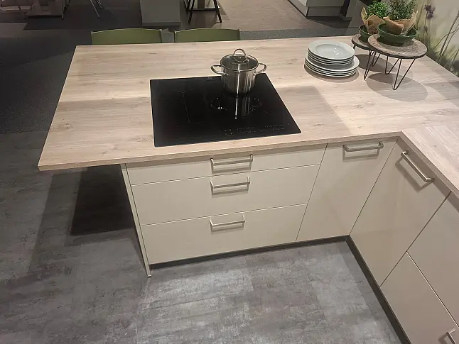 Elegante U-Küche in Crema-Magnolie Hochglanz mit warmen Sommereiche-Akzenten und exklusiver Lichtplanung