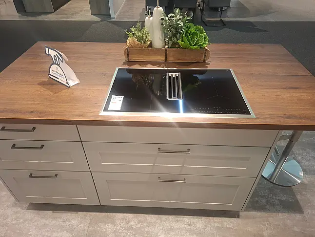 Elegante Küchenzeile mit hochwertigen Fronten in Perlgrau und warmen Alteiche-Akzenten.