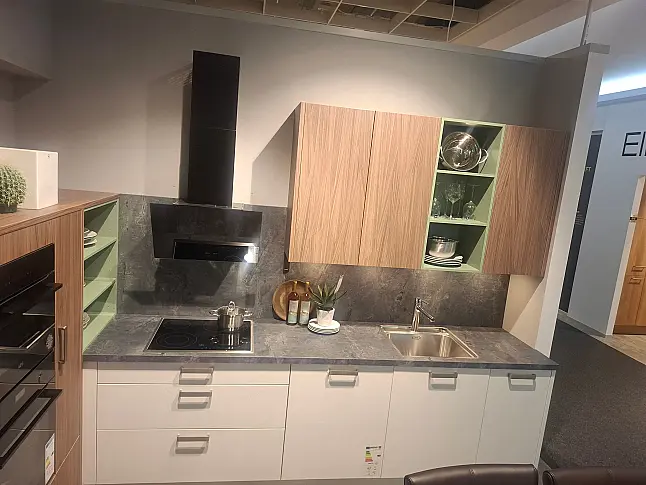 Moderne L-Küche in elegantem Weiß matt mit Akzenten in Akoni Wood und markanter Arbeitsplatte in Atlantic graphit.