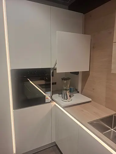 Elegante, grifflose L-Küche in Weiß Hochglanz mit warmen Asteiche-Akzenten und innovativer LED-Beleuchtung