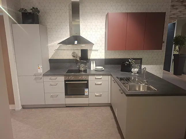 Moderne L-Küche in elegantem Platingrau mit kontrastreichen Akzenten in Hennarot und funktionaler LED-Beleuchtung