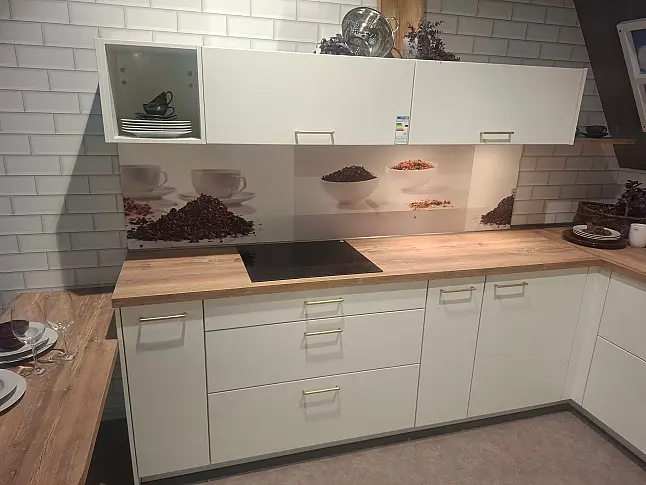 Elegante L-Küche in Weiß matt mit warmen Holz-Akzenten, inklusive Highboard-Elementen und gemütlichem Sitzbereich