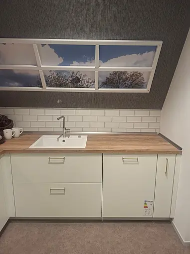 Elegante L-Küche in Weiß matt mit warmen Holz-Akzenten, inklusive Highboard-Elementen und gemütlichem Sitzbereich