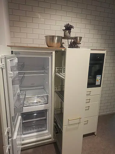 Elegante L-Küche in Weiß matt mit warmen Holz-Akzenten, inklusive Highboard-Elementen und gemütlichem Sitzbereich
