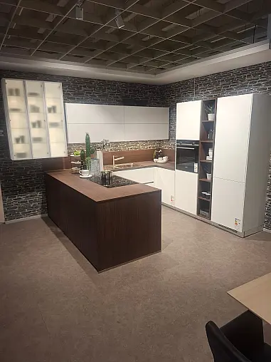 Elegante L-Küche in Weiß matt mit warmen Holz-Akzenten, inklusive Highboard-Elementen und gemütlichem Sitzbereich