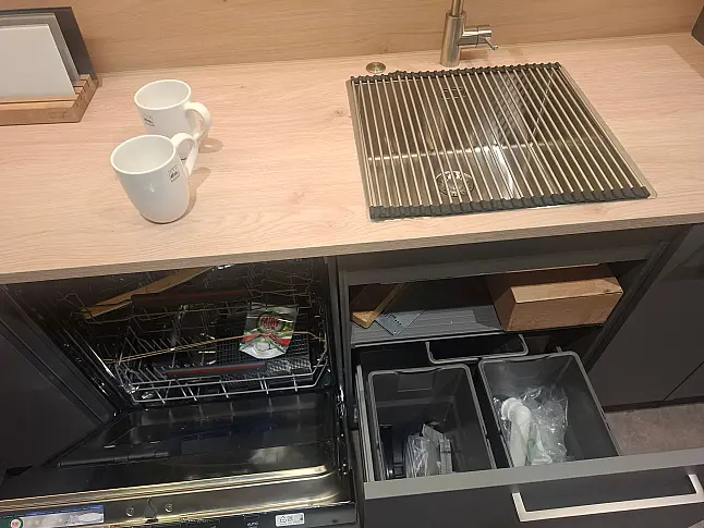 Moderne L-Küche in Quarzgrau supermatt mit Asteiche-Akzenten, integrierter LED-Beleuchtung und angeschlossenem Esstisch