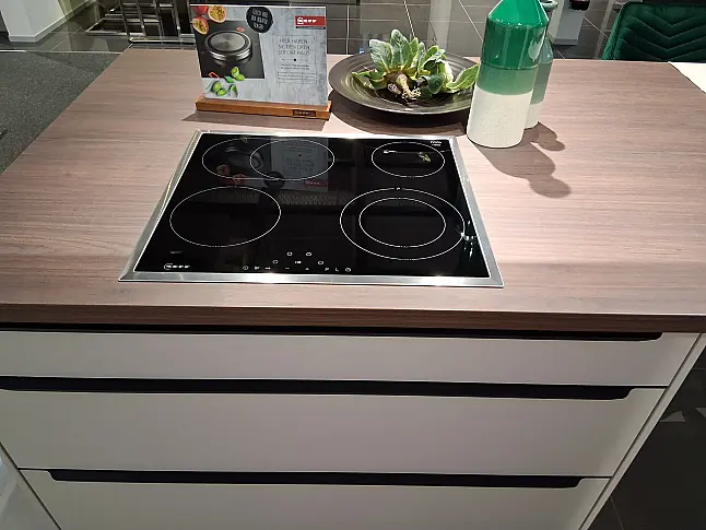 Moderne L-Küche mit freistehender Insel, eleganten Griffleisten und LED-Beleuchtung