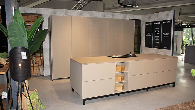 Moderne Ausstellungsküche von next125 mit Kochinsel in Saharabeige und Pocketsystem