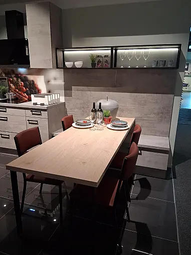 U-Küche mit integriertem Ansetztisch im eleganten Beton-Look und atmosphärischer LED-Beleuchtung