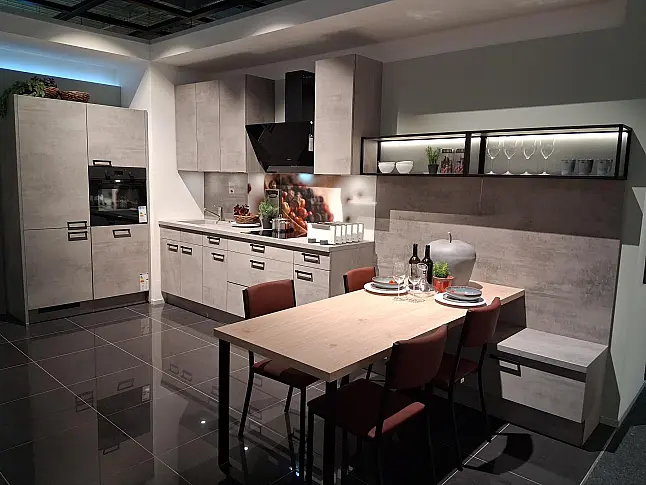 U-Küche mit integriertem Ansetztisch im eleganten Beton-Look und atmosphärischer LED-Beleuchtung