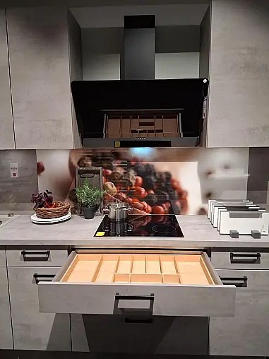 U-Küche mit integriertem Ansetztisch im eleganten Beton-Look und atmosphärischer LED-Beleuchtung