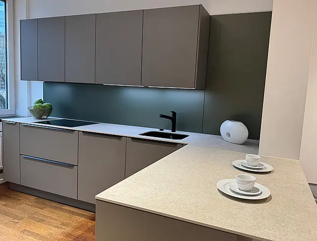 Moderne L-Küche mit innovativem Pocket-Door-System und Keramik-Arbeitsplatte