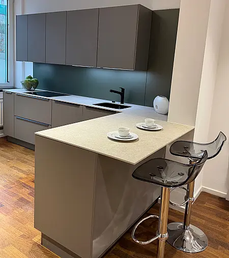 Moderne L-Küche mit innovativem Pocket-Door-System und Keramik-Arbeitsplatte