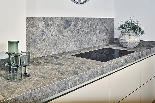 Koje 11 KL: Beige grifflose Küche mit Vitrinenschränken und Keramik Arbeitsplatte