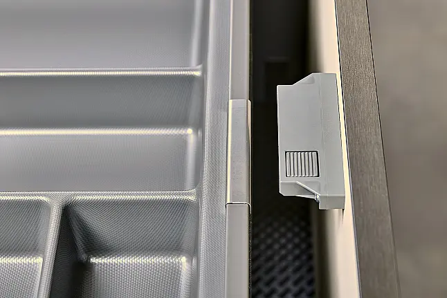 Koje 11 KL: Beige grifflose Küche mit Vitrinenschränken und Keramik Arbeitsplatte