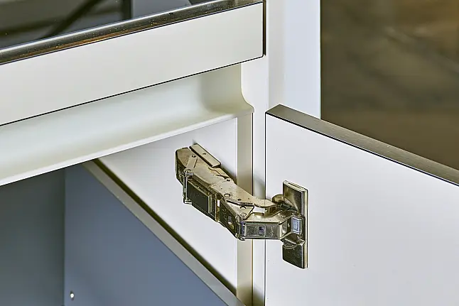 Koje 11 KL: Beige grifflose Küche mit Vitrinenschränken und Keramik Arbeitsplatte