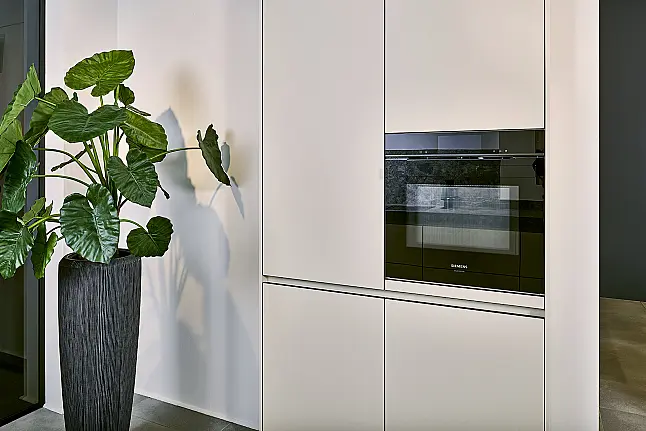 Koje 11 KL: Beige greeploze keuken met vitrinekasten en keramisch werkblad