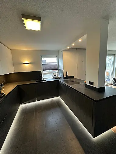 Designküche – Black Star Keramik &amp; Polarweiß Exklusive Fronten in Black Star Keramik, kombiniert mit Echtglas-Oberschränken in Polarweiß. Edles, puristisches Design mit LED-Sockelbeleuchtung und hochwertiger Ausstattung.