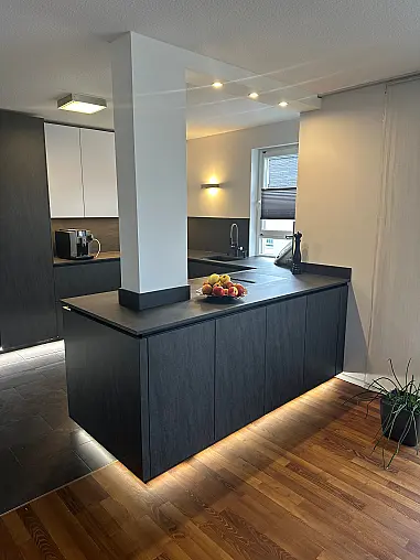 Designküche – Black Star Keramik &amp; Polarweiß Exklusive Fronten in Black Star Keramik, kombiniert mit Echtglas-Oberschränken in Polarweiß. Edles, puristisches Design mit LED-Sockelbeleuchtung und hochwertiger Ausstattung.