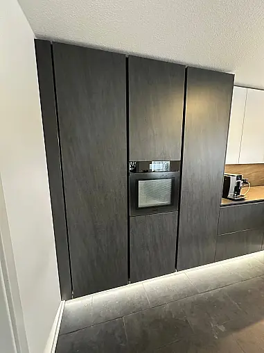 Designküche – Black Star Keramik &amp; Polarweiß Exklusive Fronten in Black Star Keramik, kombiniert mit Echtglas-Oberschränken in Polarweiß. Edles, puristisches Design mit LED-Sockelbeleuchtung und hochwertiger Ausstattung.