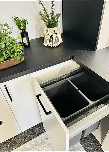 Moderne helle Küche in L-Form mit schwarzer AP
