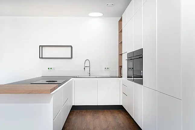 Moderne, grifflose U-Küche mit keramischer Arbeitsplatte