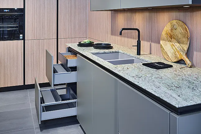Koje 28 KL: Eckküche in Eiche und Taupe mit Naturstein Arbeitsplatte