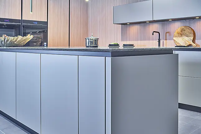 Koje 28 KL: Eckküche in Eiche und Taupe mit Naturstein Arbeitsplatte