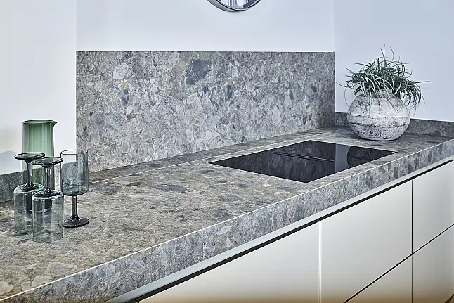 Koje 11 KL: Beige greeploze keuken met vitrinekasten en keramisch werkblad