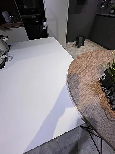 Ausstellungsküche mit abgerundeter Insel und stylischer Inselhaube