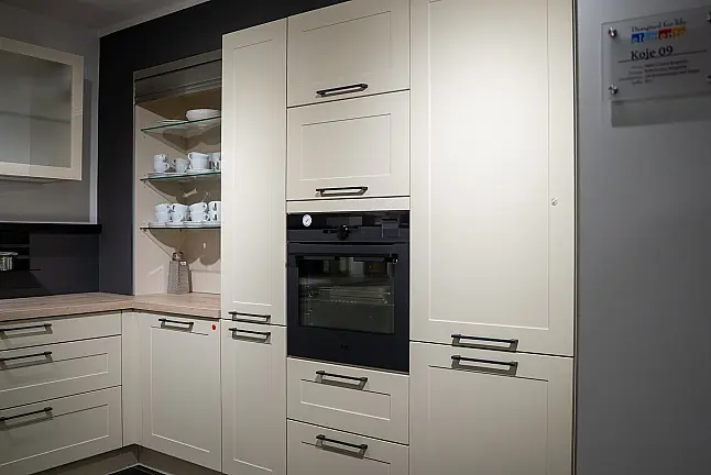 Häcker concept130 Landhausküche in Crema-Magnolie mit Halbinsel – AEG-Geräte inkl. Deckenlüfter, Weinkühler &amp; Kaffeevollautomat | Ausstellungsküche
