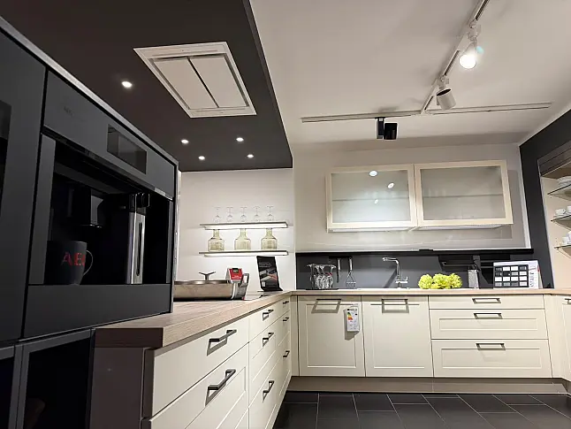 Häcker concept130 Landhausküche in Crema-Magnolie mit Halbinsel – AEG-Geräte inkl. Deckenlüfter, Weinkühler &amp; Kaffeevollautomat | Ausstellungsküche