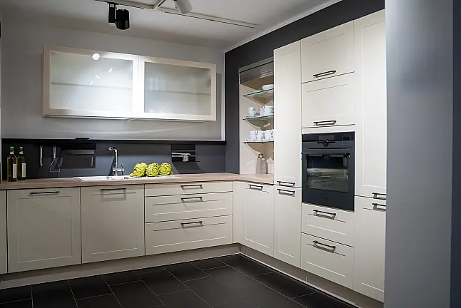 Häcker concept130 Landhausküche in Crema-Magnolie mit Halbinsel – AEG-Geräte inkl. Deckenlüfter, Weinkühler &amp; Kaffeevollautomat | Ausstellungsküche