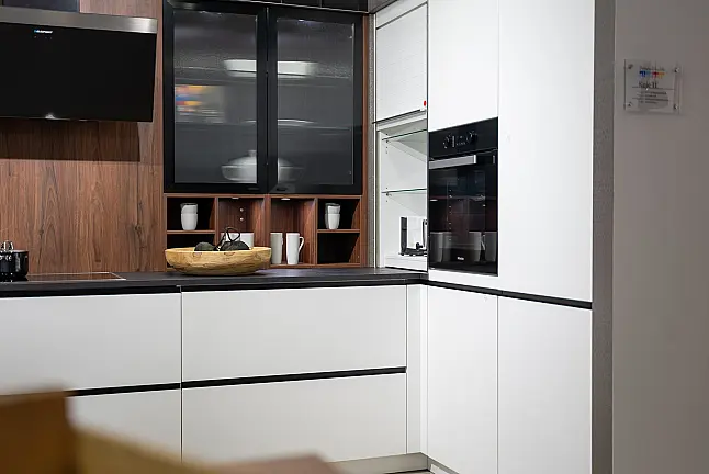 Häcker concept130 grifflose Küche in Kristallweiß – L-Form mit Riffelglas-Vitrinen, Miele &amp; AEG Induktion | Ausstellungsküche