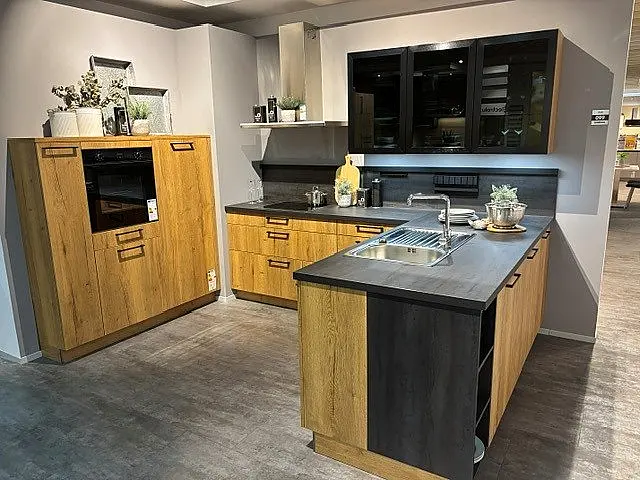Moderne L-Küche mit separatem Hochschrank-Block, schwarzer Arbeitsplatte und LED-Glastüren