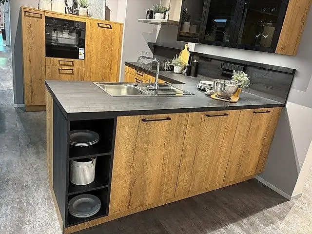 Moderne L-Küche mit separatem Hochschrank-Block, schwarzer Arbeitsplatte und LED-Glastüren