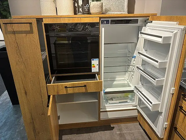 Moderne L-Küche mit separatem Hochschrank-Block, schwarzer Arbeitsplatte und LED-Glastüren